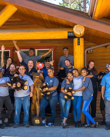 The Redwoods staff team posing and celebrating outside the lodge entrance