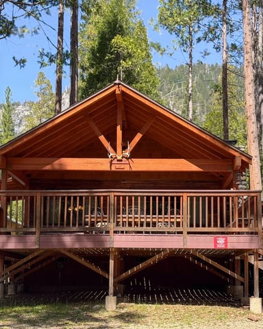 Deer Den cedar A-frame cabin with exposed beams and granite mountain visible through the trees