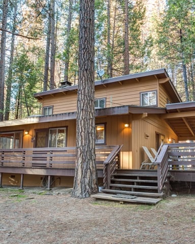 Cutter's Edge cabin with wide deck among tall pines at dusk