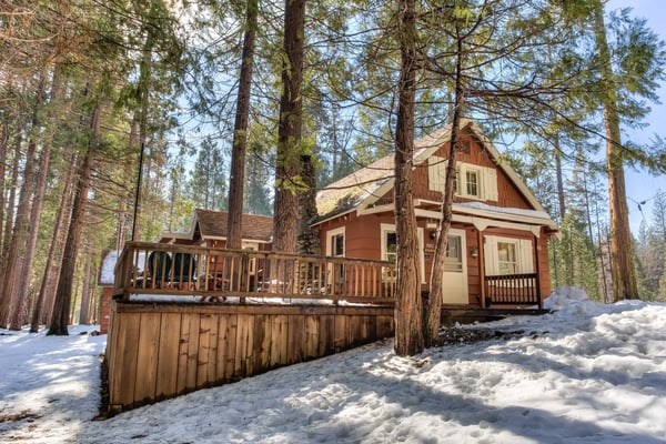 Red cabin with white shutters in a snowy Wawona forest in winter